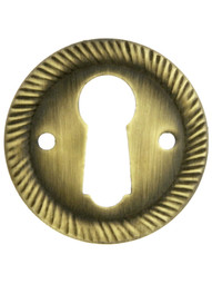 Stamped Brass Round Keyhole Cover with Rope Design in Antique Brass.